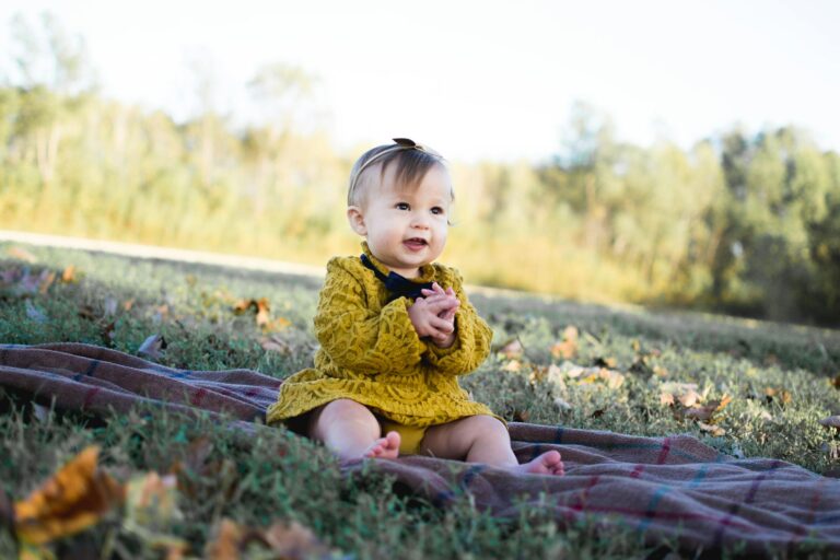 baby wearing yellow crochet long sleeve dress sitting on brown textile